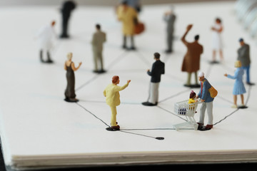 close up of miniature people with social network diagram on open