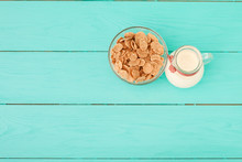 Jug Of Milk And Muesli On Blue Wooden Table. Top View