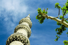 Minaret And Tree On The Blue Sky Background.