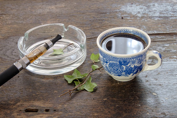 Wall Mural - e-cigarette cup of coffee on a wooden background healthy