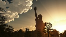 Statue Of Liberty On The Background Of Sunset And Cloudy Sky