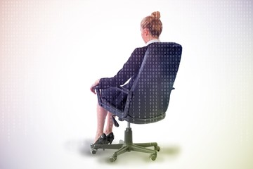 Fototapete - Businesswoman sitting on swivel chair in black suit
