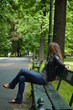 Samotna kobieta siedząca na ławce w parku