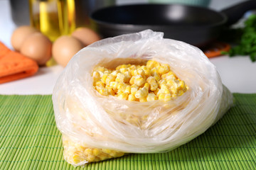 Canvas Print - Frozen corn in bag on kitchen table close up