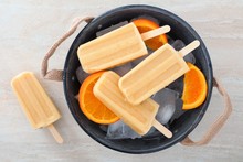 Homemade Orange Yogurt Popsicles In A Rustic Ice Filled Tin Pail