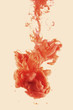 Ink Color drop swirling underwater, apricot background.