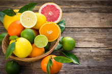 Fresh And Juicy Citrus Fruits In The Basket On The Rustic Table
