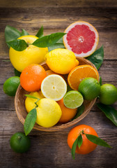 Wall Mural - Fresh and juicy citrus fruits in the basket on the rustic table