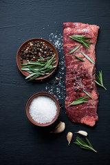 Poster - Raw machete beef steak with seasonings over black wooden surface