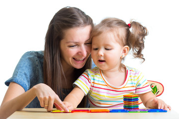 child and mom playing together with toys