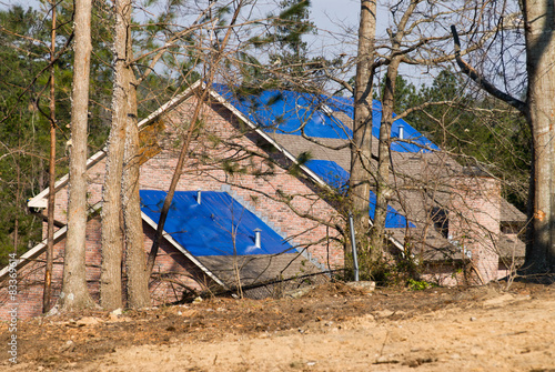 Fotografie, Obraz tornado damaged house with a blue tarpaulin on the roof