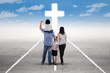 © Creativa Images - Young family follow a cross on the road
