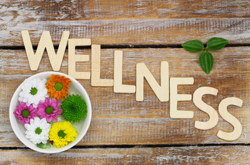 Wall Mural - Wellness written with wooden letters and Santini flowers
