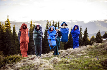 group of hikers jumping in sleeping bags in mountains