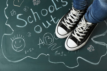 Wall Mural - Female feet on blackboard background with inscriptions and sketches