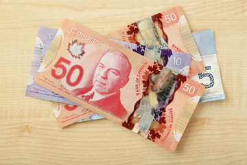 Wall Mural - Canadian dollars on wooden table