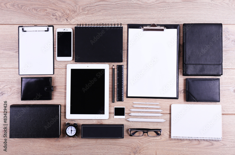 Set of black and white accessories on wooden table, top view