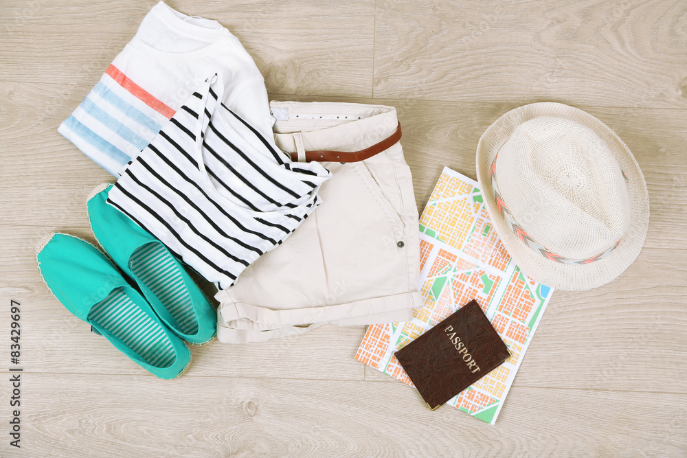 Summer vacation clothes, shoes and hat on wooden background