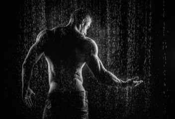 very muscular handsome athletic man in the rain