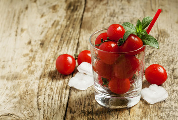 Funny cool tomato juice and tomatoes in a glass, selective focus