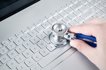 Diagnosis and repair of computers. Stethoscope on laptop