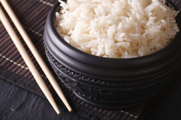 Asian food: boiled rice in a black bowl macro horizontal 
