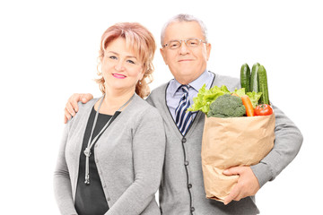 Poster - Mature couple posing with a bag of groceries