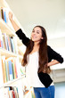© Flamingo Images - Young woman reaching for a book