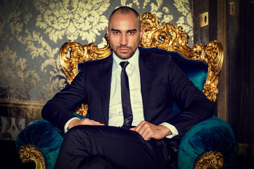 Man in a suit sitting on chair.