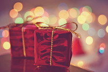Two Red Christmas Gift Packages On Bokeh Background Of Holiday Lights.
