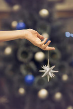 Silver Christmas Star Against Blurred Decorated Christmas Tree