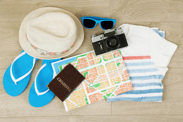 Summer vacation clothes, shoes and hat on wooden background