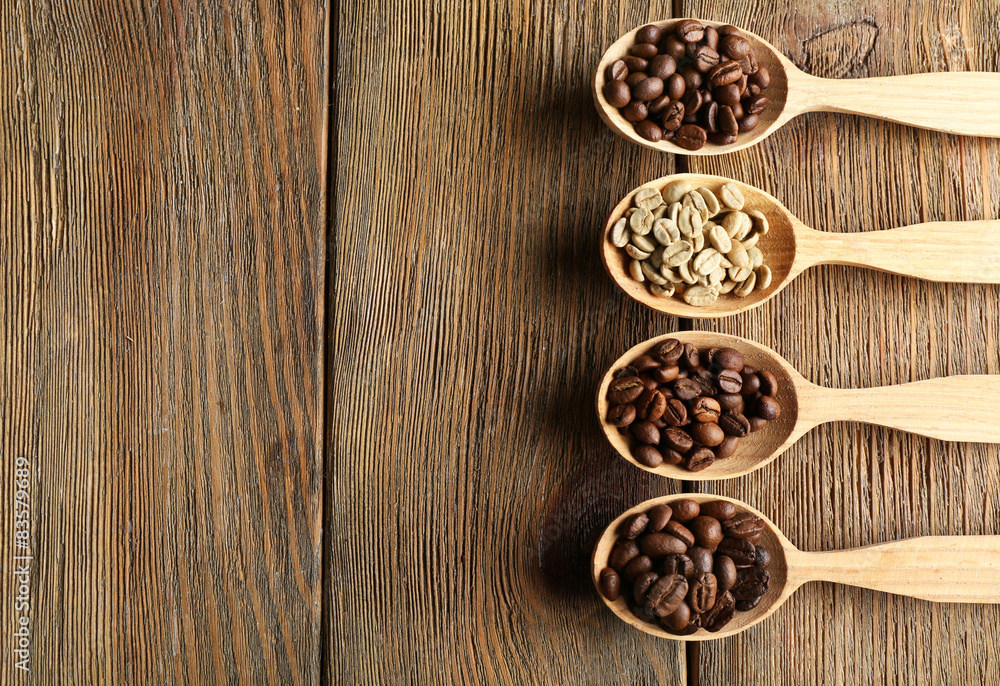 Coffee beans in spoons on wooden background