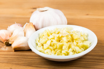 Chopped garlic in a plate with garlic bulb and cloves