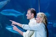 Happy couple pointing a fish tank