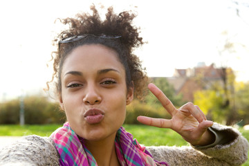 Wall Mural - Cute girl making fun face with peace sign