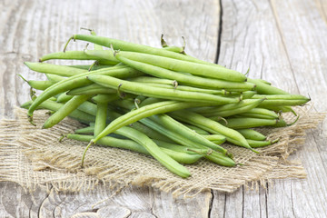 Poster - green beans on wooden background