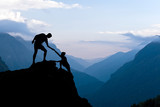 Fototapeta Desenie - Teamwork couple climbing helping hand