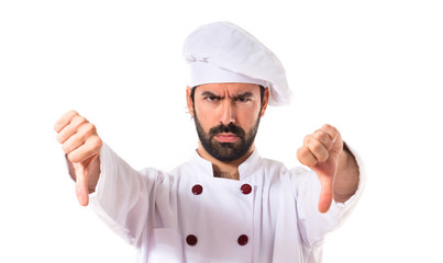 Wall Mural - Chef doing a bad signal over white background