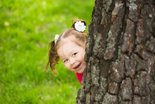 Cute Little Girl Hiding Behind Huge Tree