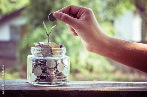 Fotografía Poner monedas de dinero con efecto de filtro época de estilo retro mano
