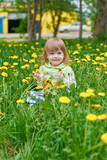 Fototapeta Dmuchawce - Little girl walks in the park