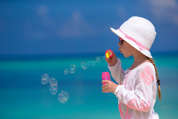 Wall Mural - Adorable little girl making soap bubbles during summer vacation