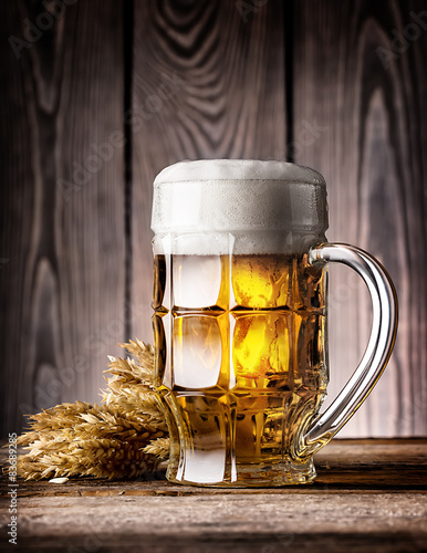 Foto Faceted mug of light beer with foam and ears