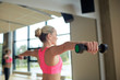 © Syda Productions - woman with dumbbells flexing muscles in gym