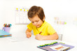Concentrated small boy write with pencil alone