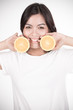 © Nonwarit - Young woman holding fresh oranges. Healthy eating. Isolated over