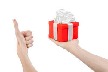 hand holding a gift wrapped in red box with white ribbon and bow