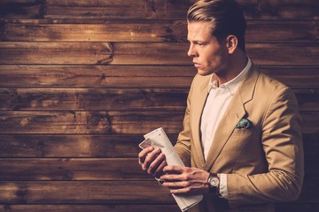 Wall Mural - Stylish man with newspaper in rural cottage interior