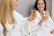 © Syda Productions - happy women in bathrobes with champagne glasses